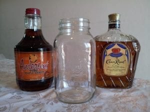 A bottle of maple syrup, an empty mason jar and a bottle of crown royal whiskey- all required to make maple liqueur